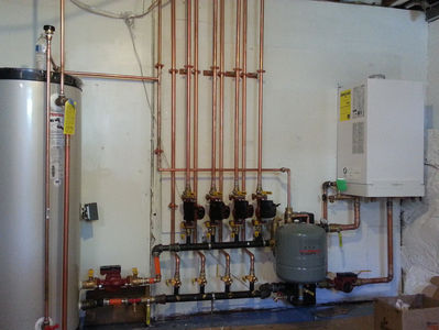 Technician inspecting an oil burner before winter in a Saugus, MA home